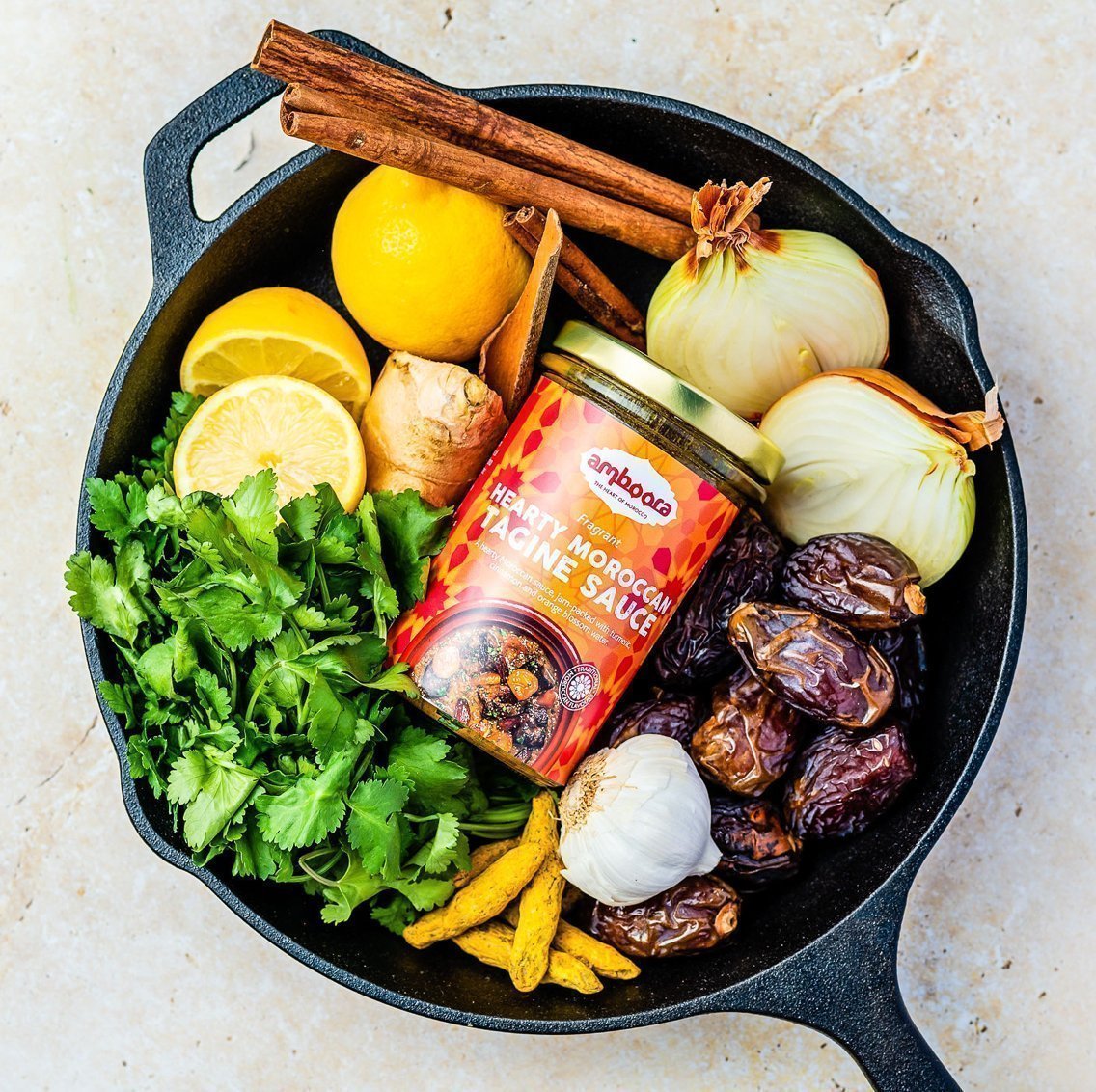 Amboora Moroccan Tagine Cooking Sauce in a jar in a pan surround with ingredients